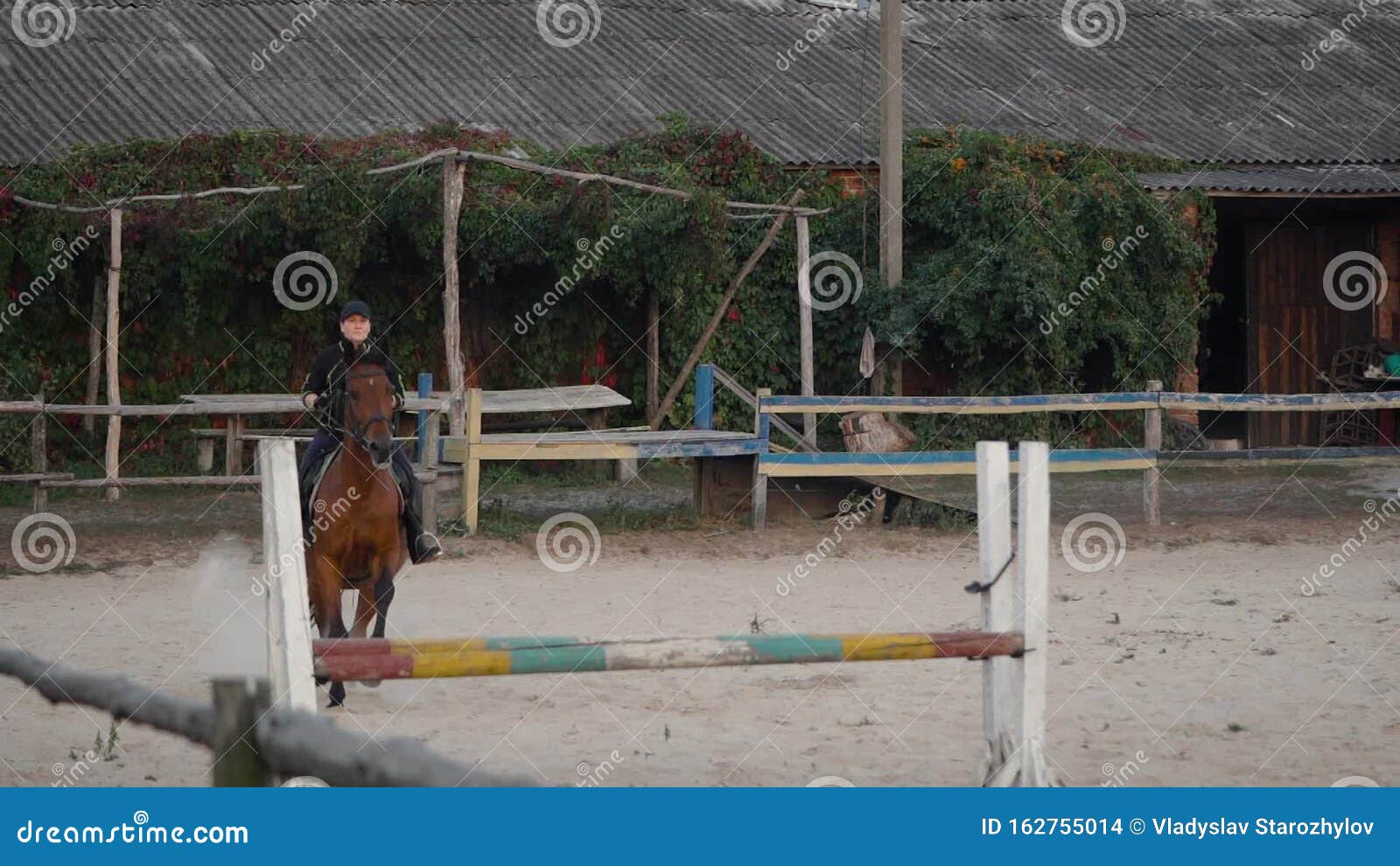 Uma pessoa andando a cavalo está pulando uma cerca.