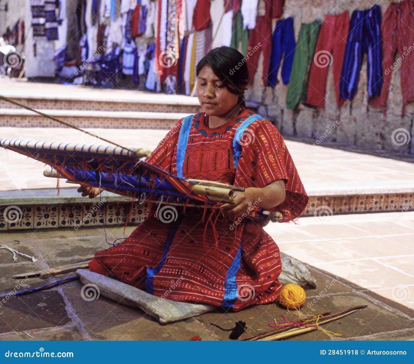 Uma jovem mulher de oaxaca com a cintura tradicional do tear.