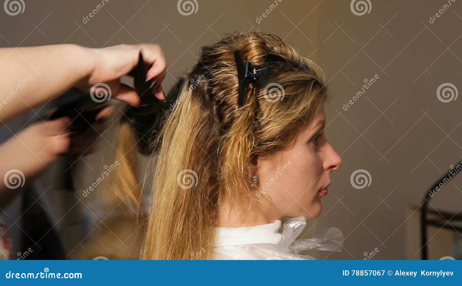 Cabeleireiro seca e modela o cabelo com um secador de cabelo no salão de  beleza