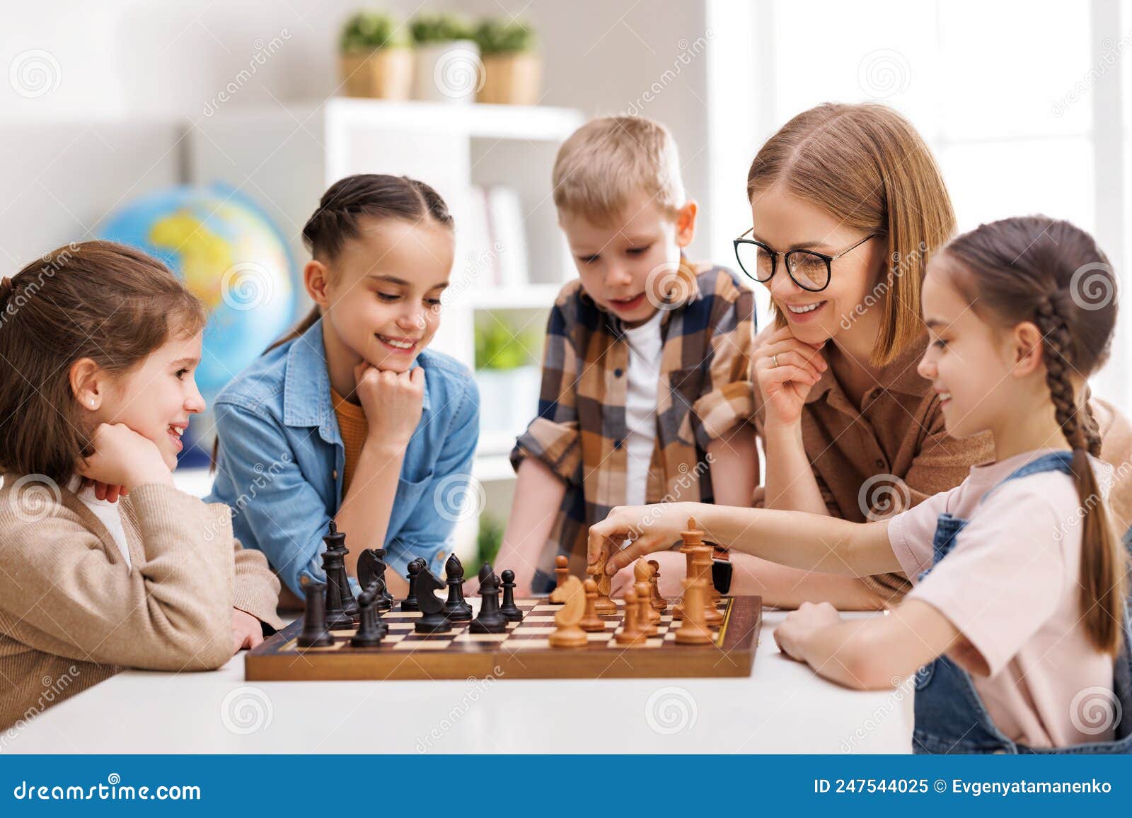 Mulher Ensinando Crianças a Jogar Xadrez Na Escola Foto de Stock