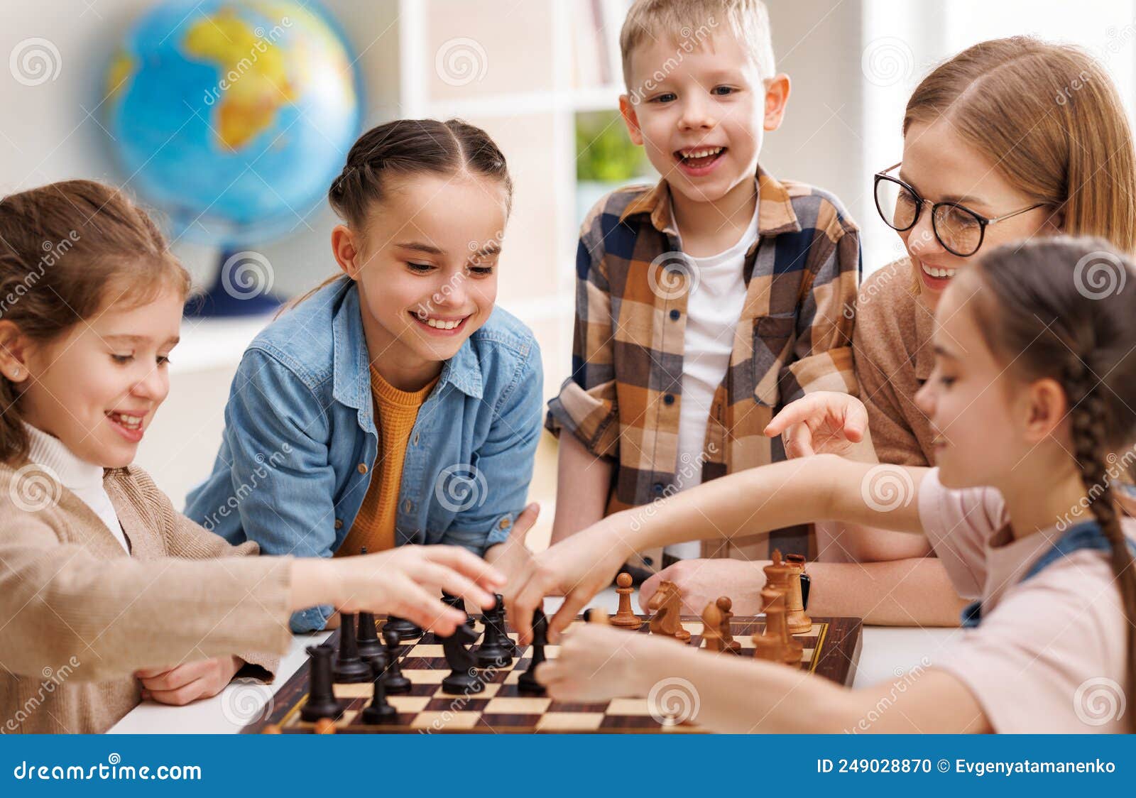 Mulher Ensinando Crianças a Jogar Xadrez Na Escola Foto de Stock