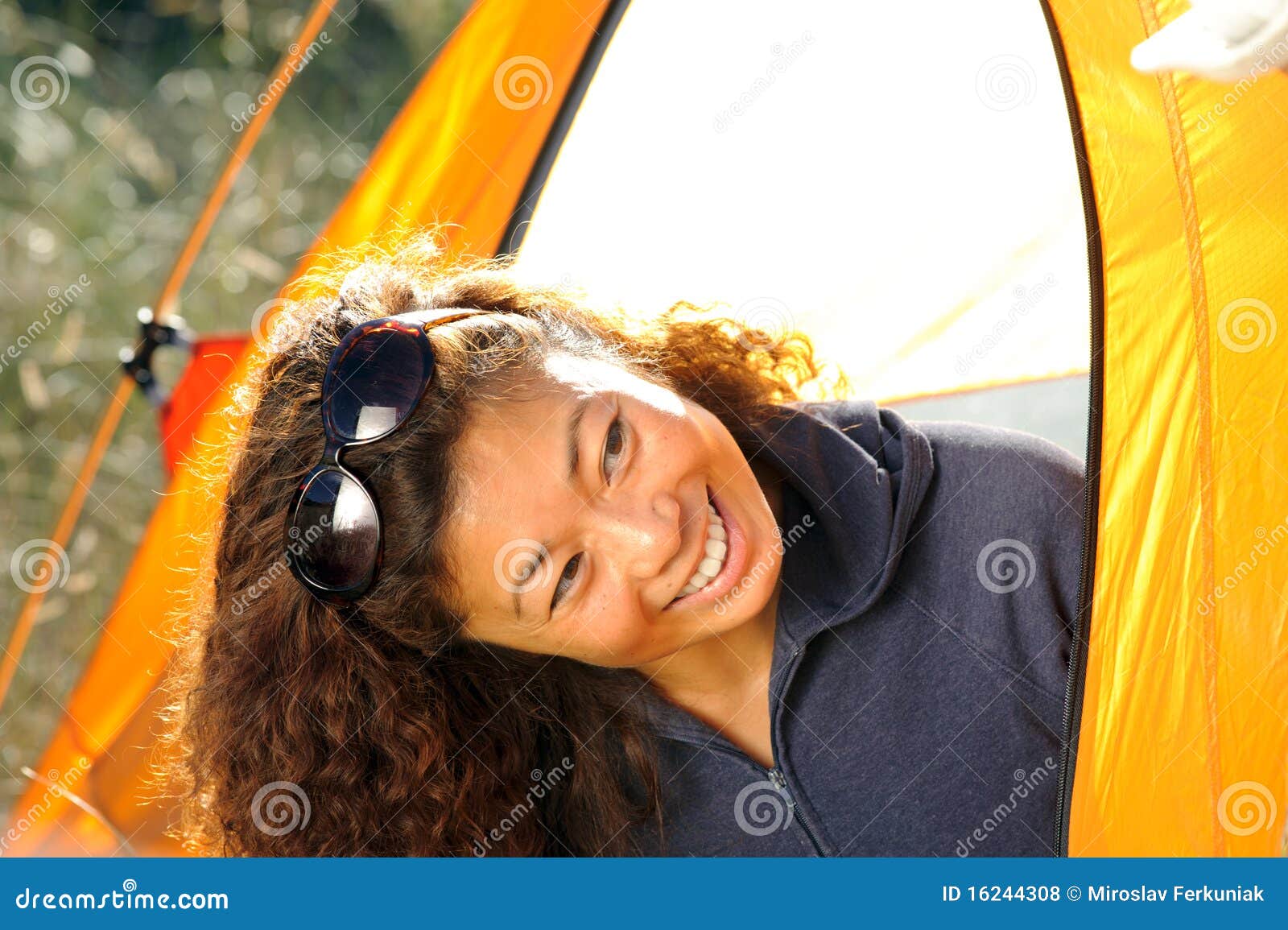 Mulher feliz que acampa para fora na barraca. Mulher nova que acampa nas montanhas rochosas