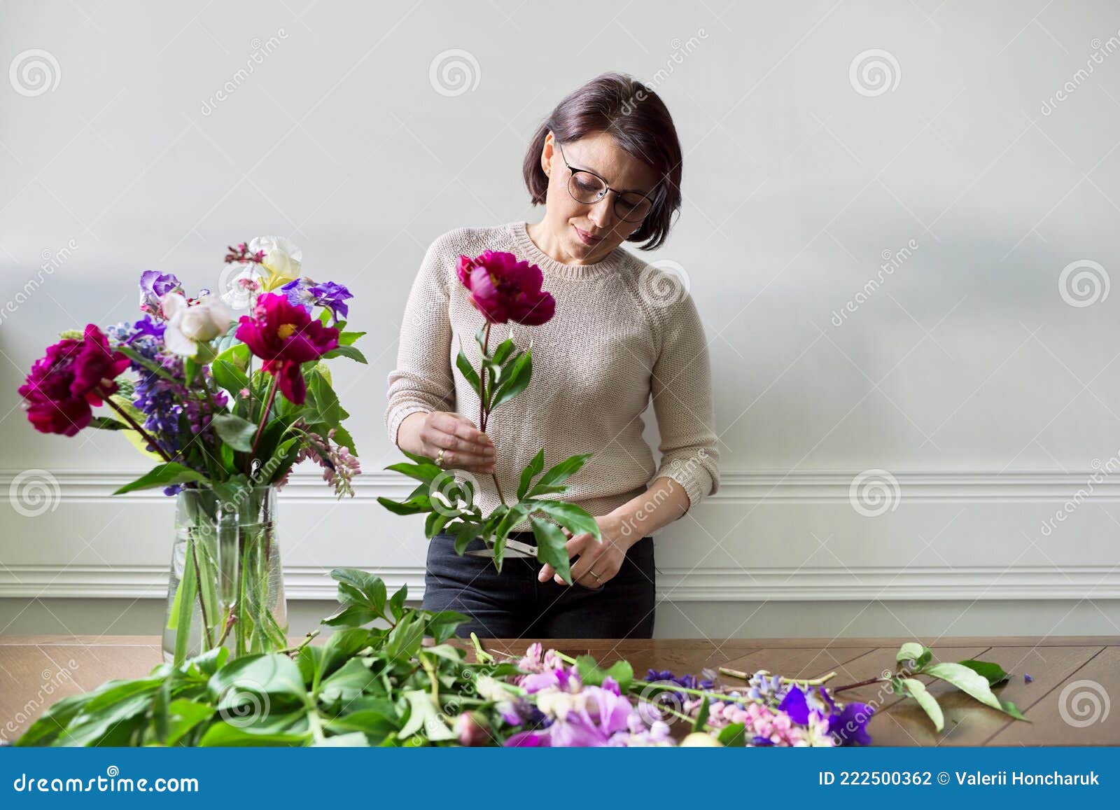 Mulher Madura Em Casa Com Flores De Primavera Foto de Stock - Imagem de  verde, fundo: 222500362