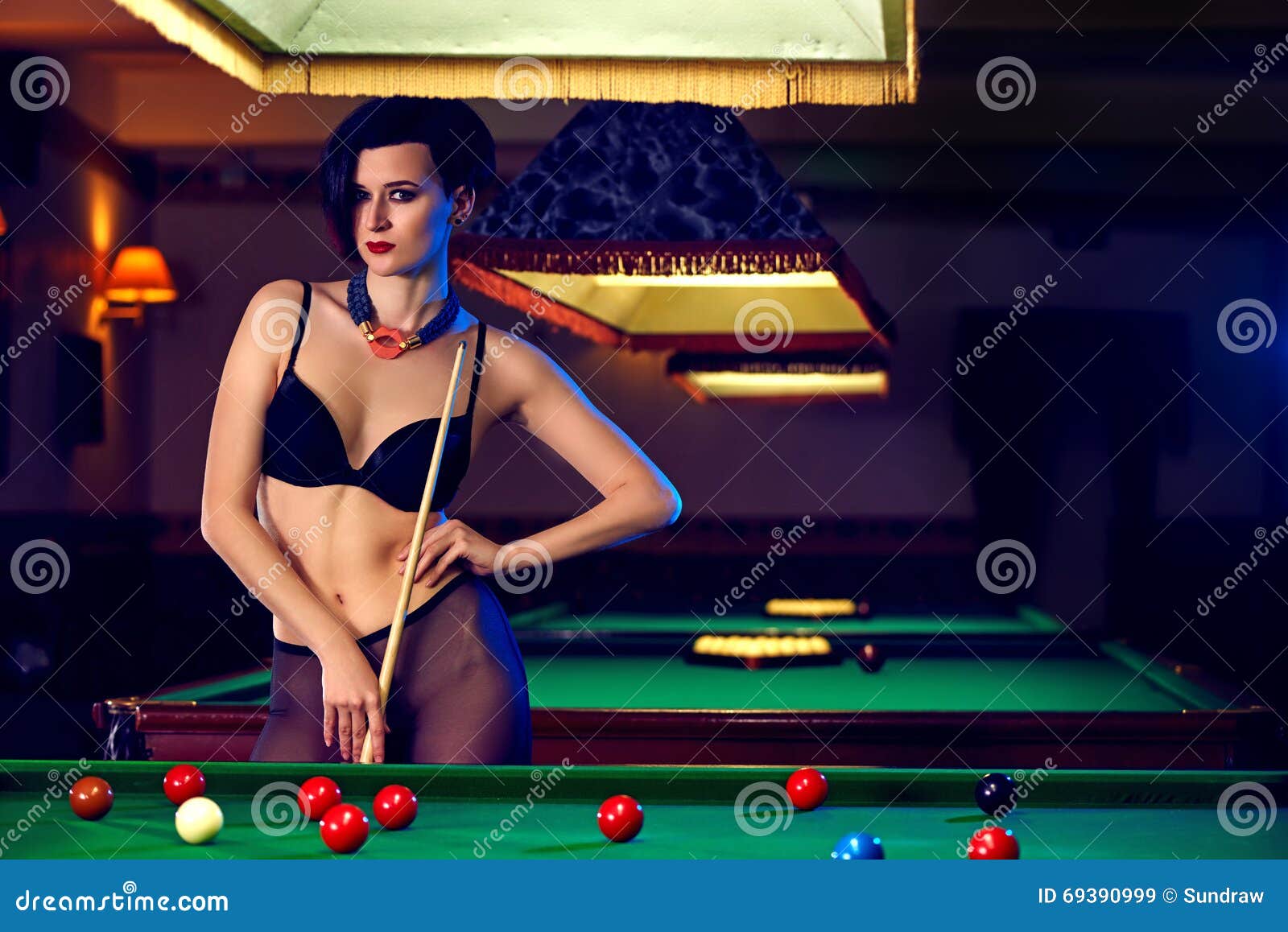 Garota sexy encontra-se na mesa de sinuca entre as bolas. jogo de