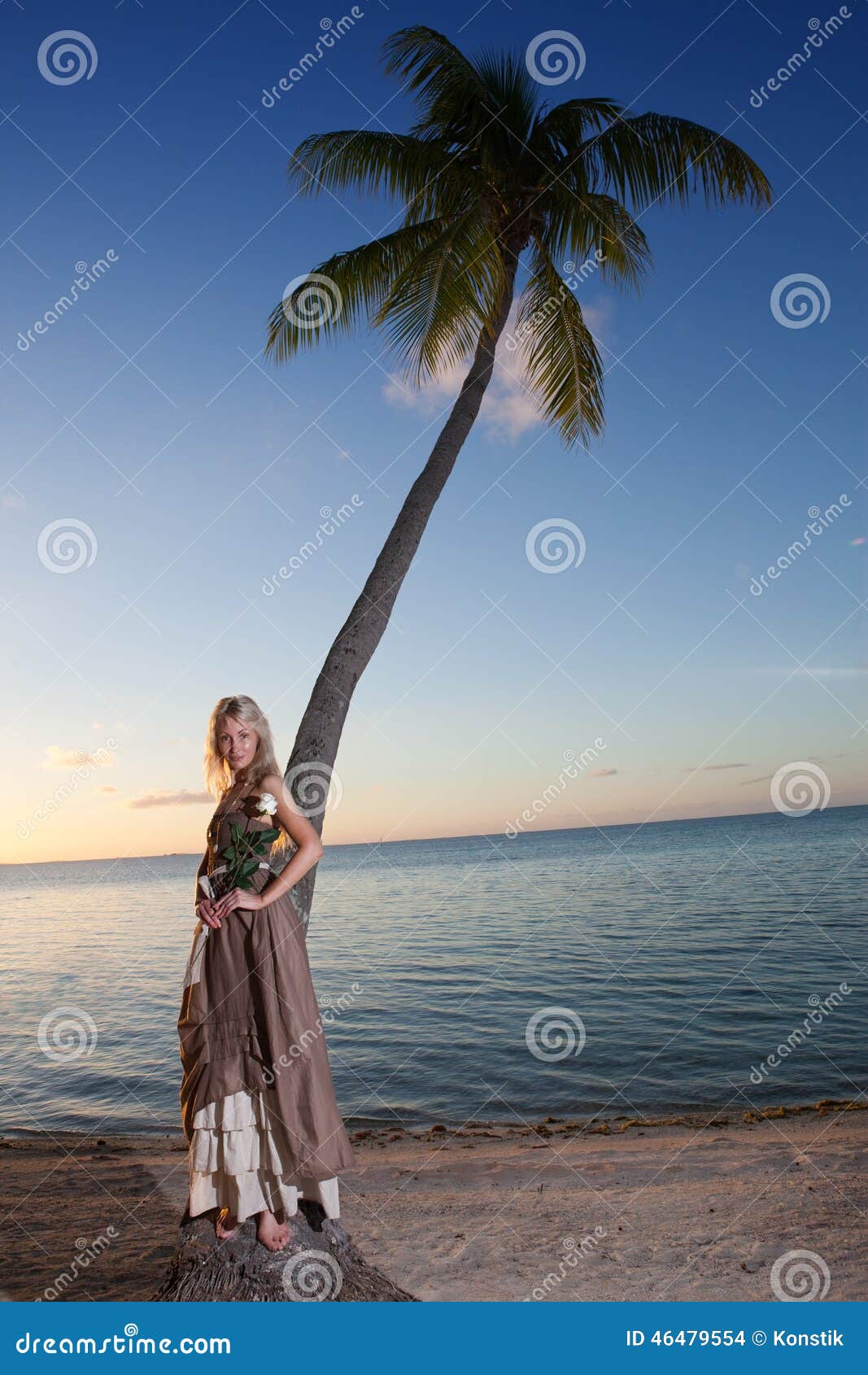 A mulher nova no sundress longos em uma praia tropical polynesia. A jovem mulher no sundress longos na praia tropical polynesia