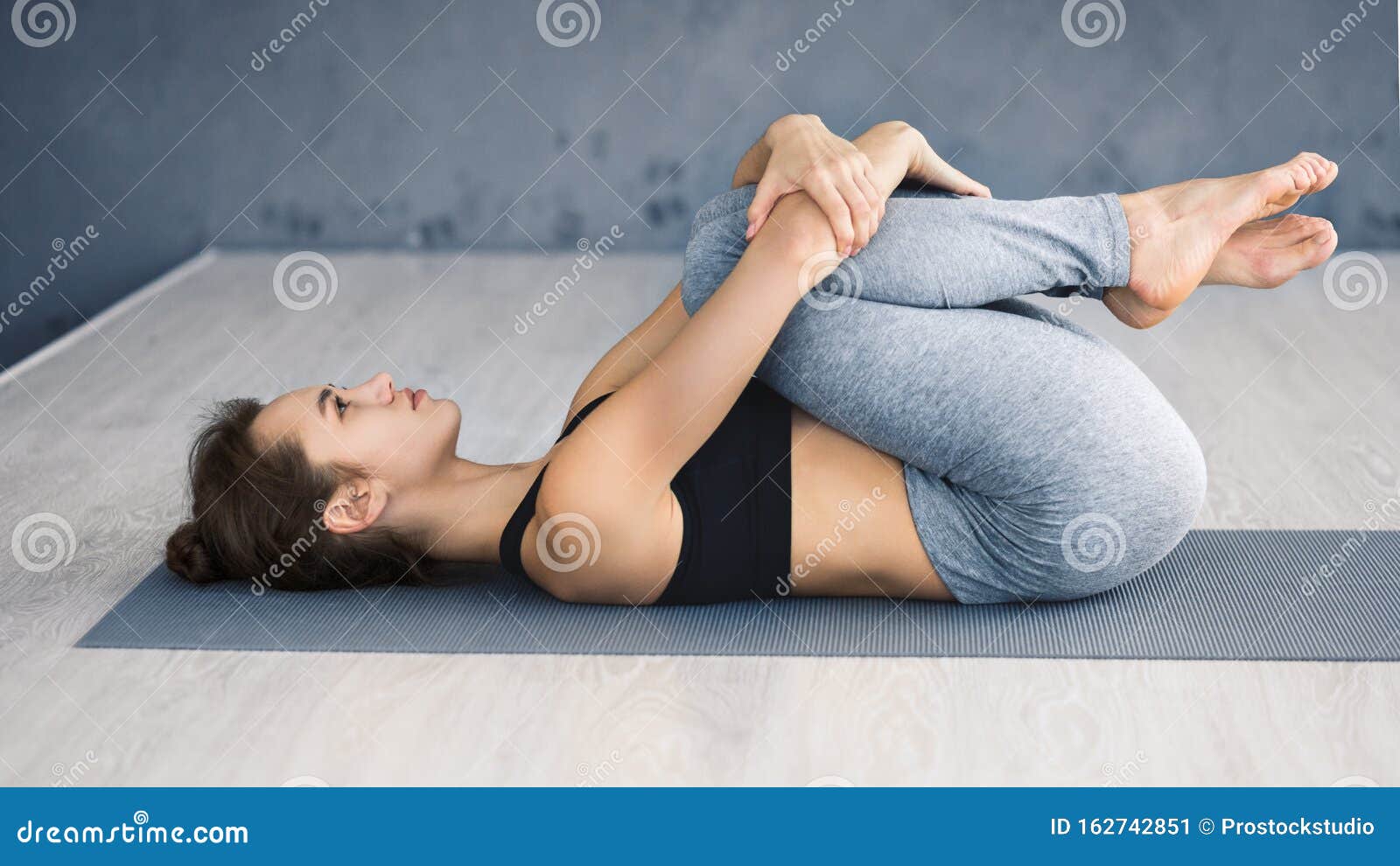 Uma mulher está ajoelhada no chão com o braço dobrado e exercícios de ioga  asana fotos, imagens de © ShotStudio #453397350