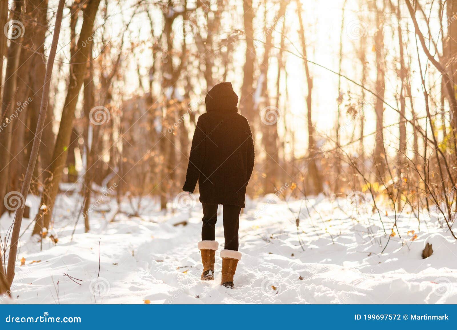Mulher que caminha na neve do inverno caminhando na floresta nevada na floresta trilhando pessoas ativas no estilo de vida ao ar