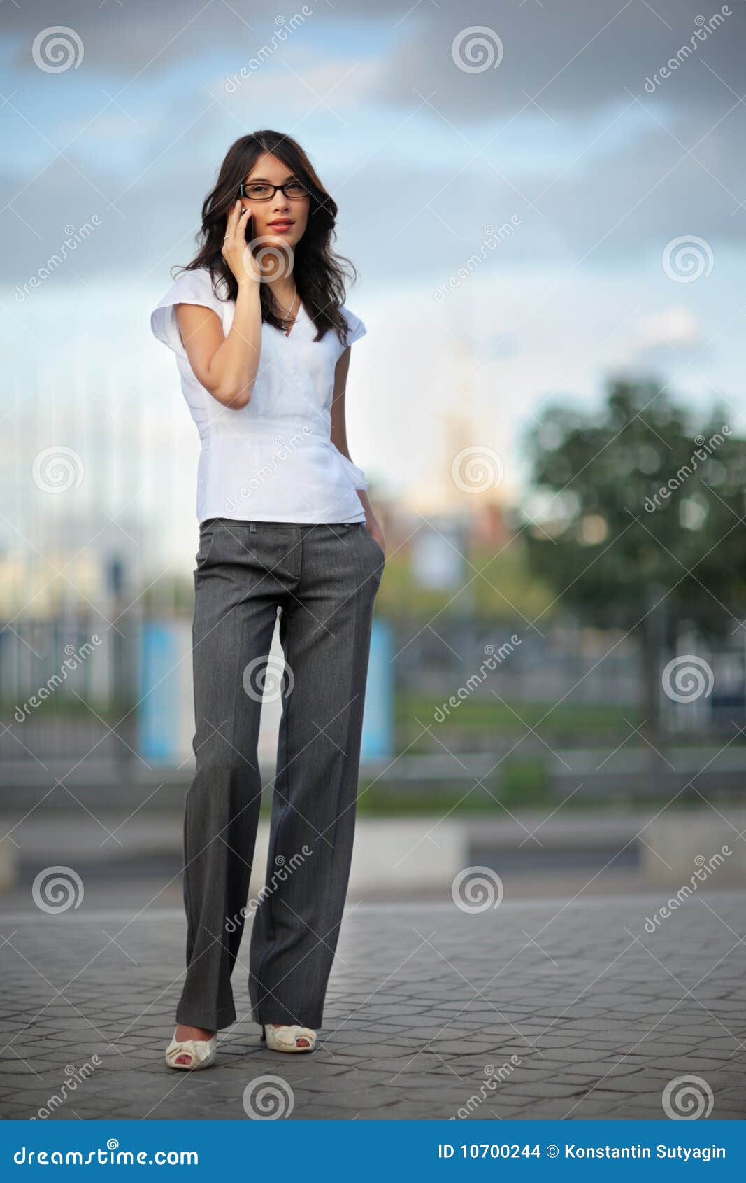 Mulher que fala no telefone. Mulher bonita que fala no telefone móvel na cidade. DOF raso.