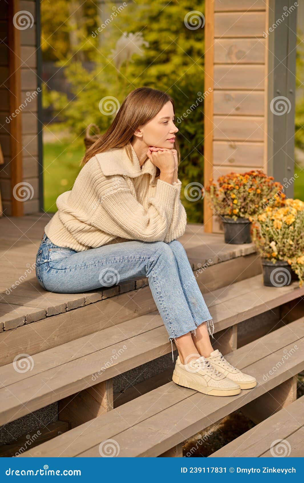 Mulher fazendo ligação sentada na varanda de casa perto da porta e