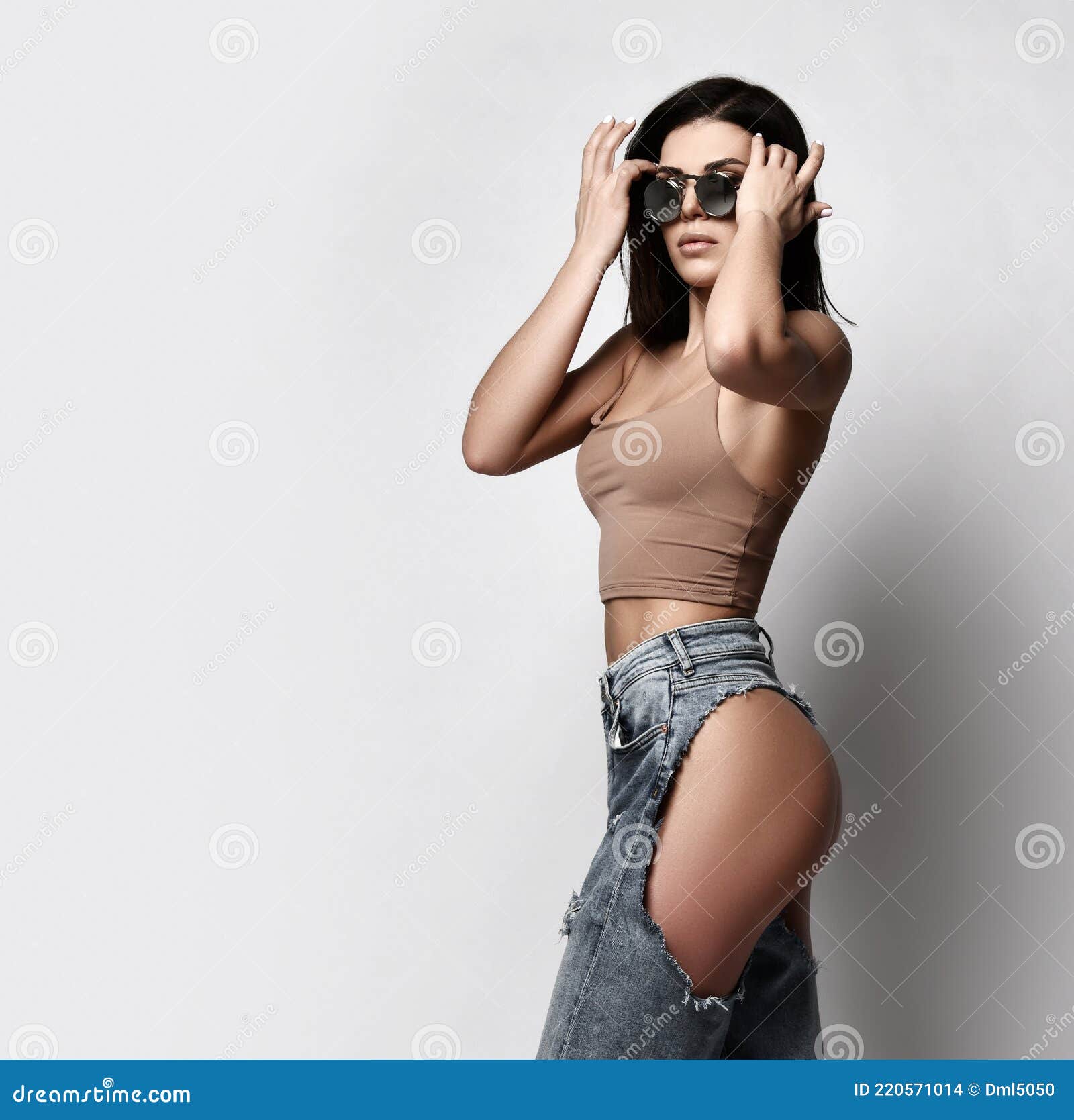 Mulher Sexy E Autoconfiante Caminha Em Jeans Rasgados Com óculos De Sol E Topo De Bunda Pelados