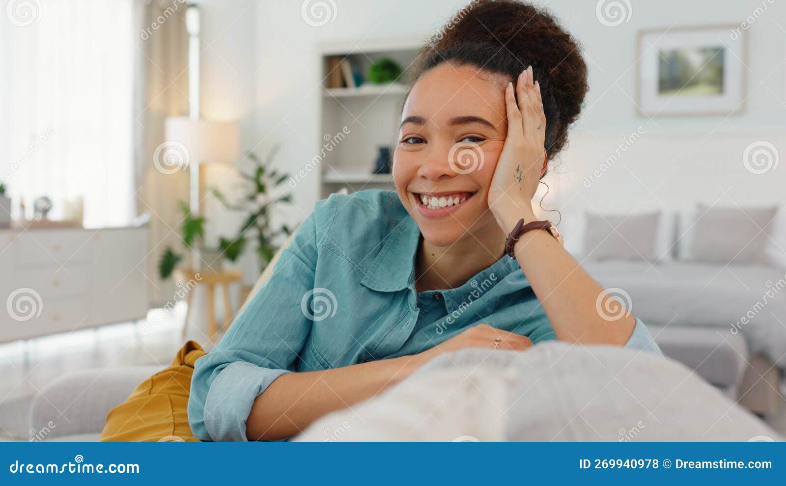 Garota feliz com telefone relaxa no sofá ou no sofá da sala