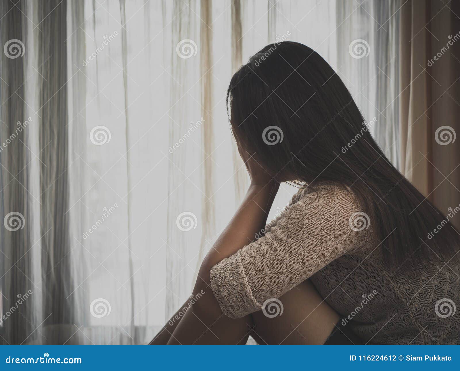 Mulher triste sentada sozinha em uma sala vazia