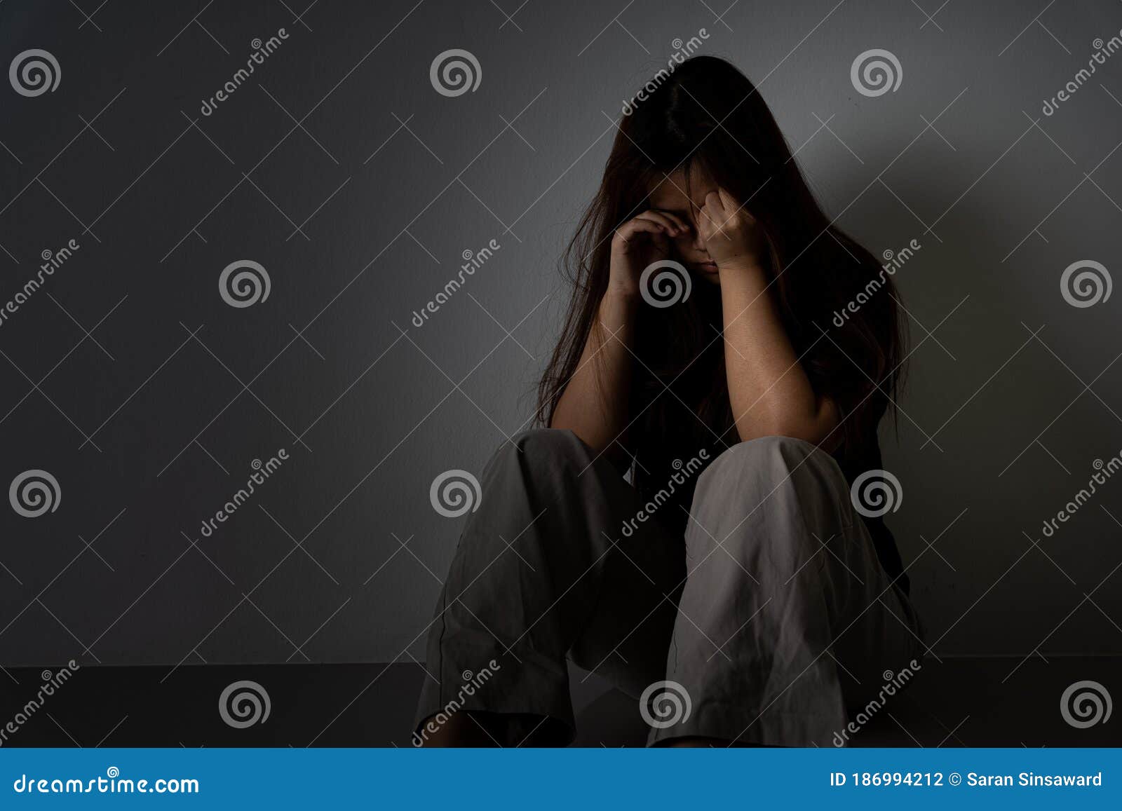 A mulher com depressão abraça o joelho e chora. a mulher triste