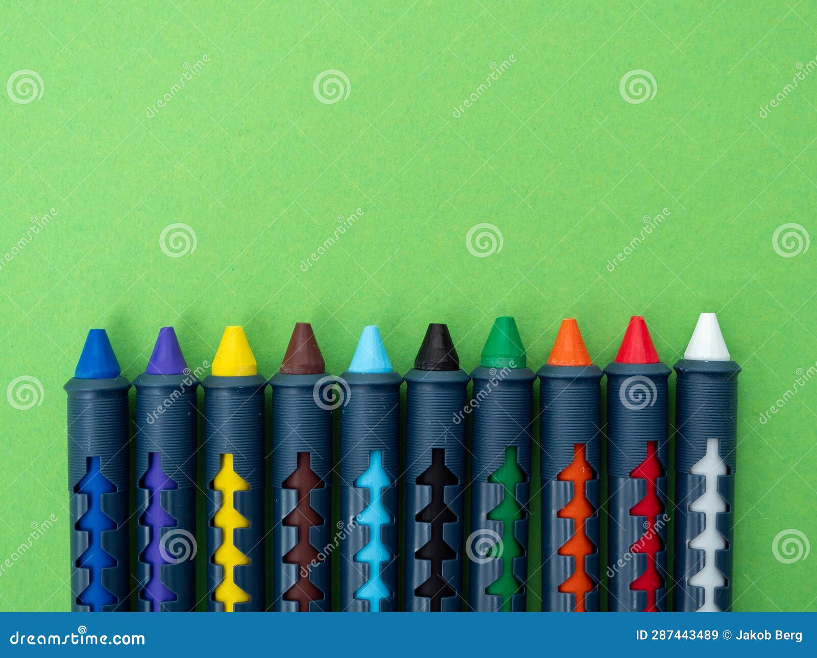 Multicolored Crayons for Drawing on a Green Background. Stock Image