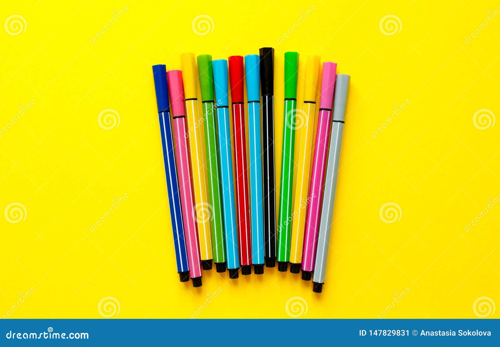 multi-colored felt-tip pens on yellow background. top view,business, office supplies. school office supplies. minimal style. colo