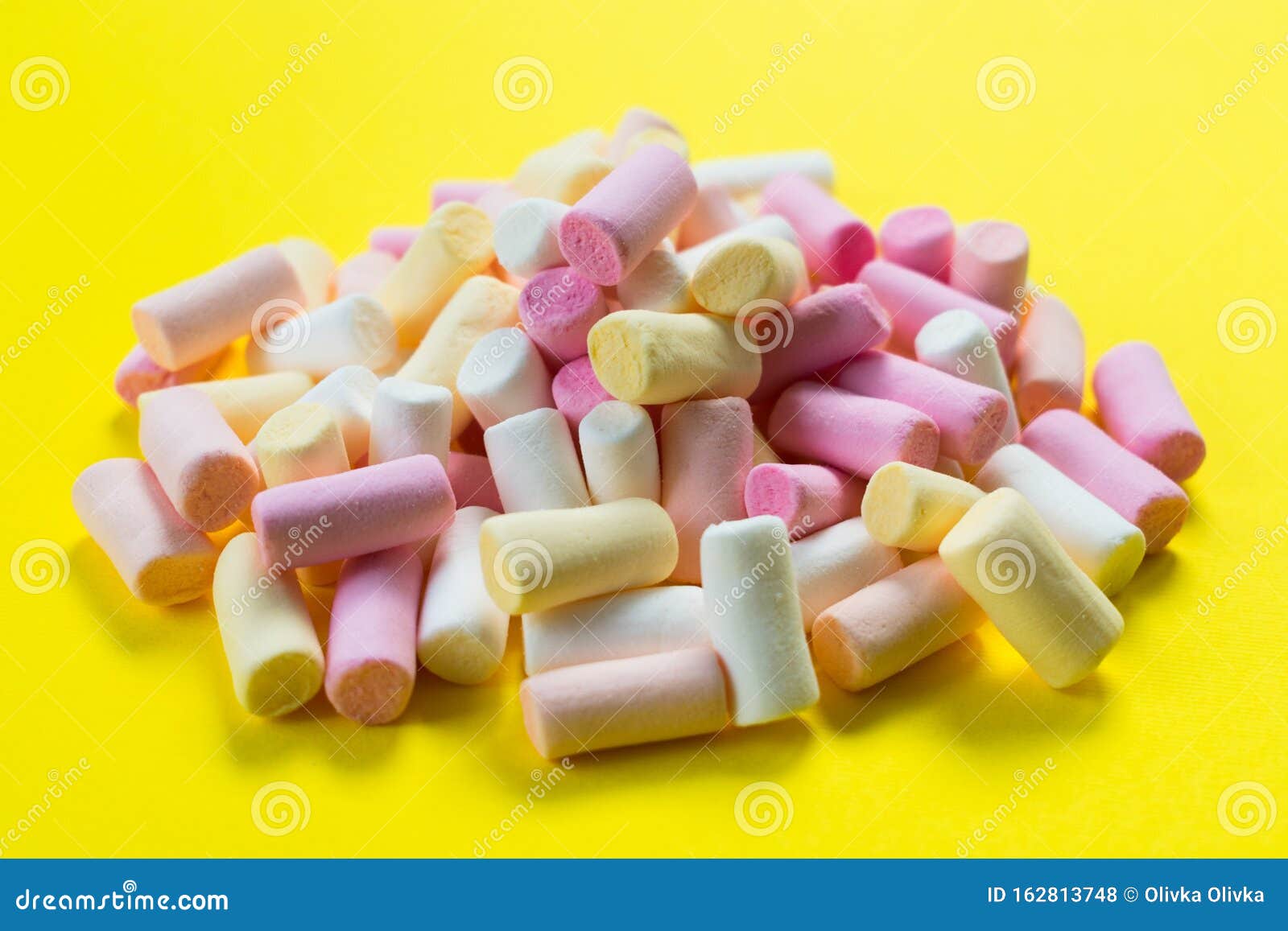 Multicolored Little Marshmallows on a Bright Yellow Background. Stock