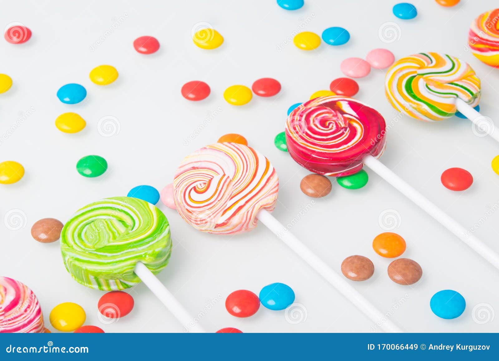 Multi-colored Lollipops, Arranged in a Row and Round Dragees, on a ...