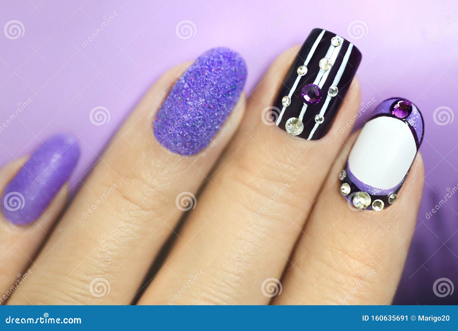 multi-colored manicure with white and lilac varnish on various forms of nails