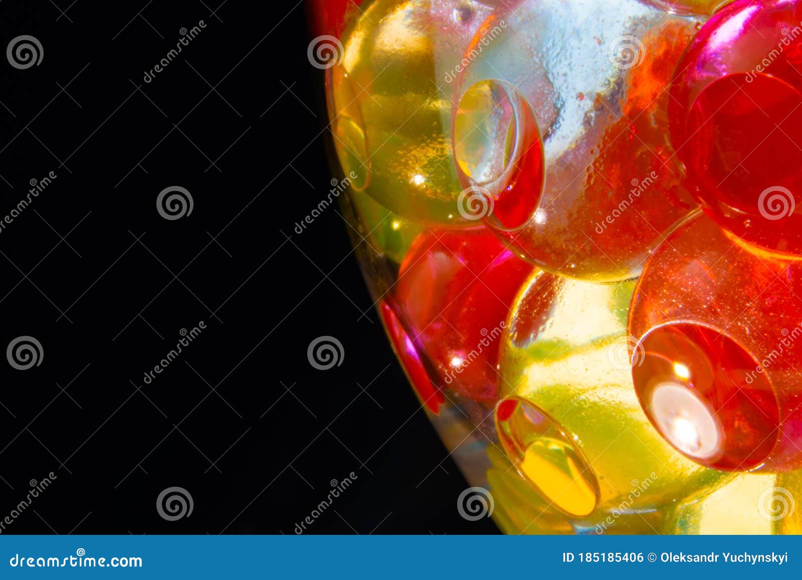 Multicolored Silicone Gel Balls in a Glass on a Black Background Stock
