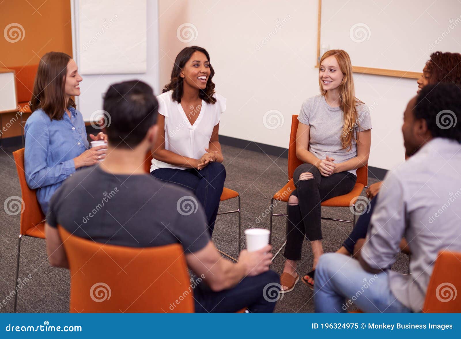 multi-cultural group of men and women at mental health group therapy meeting