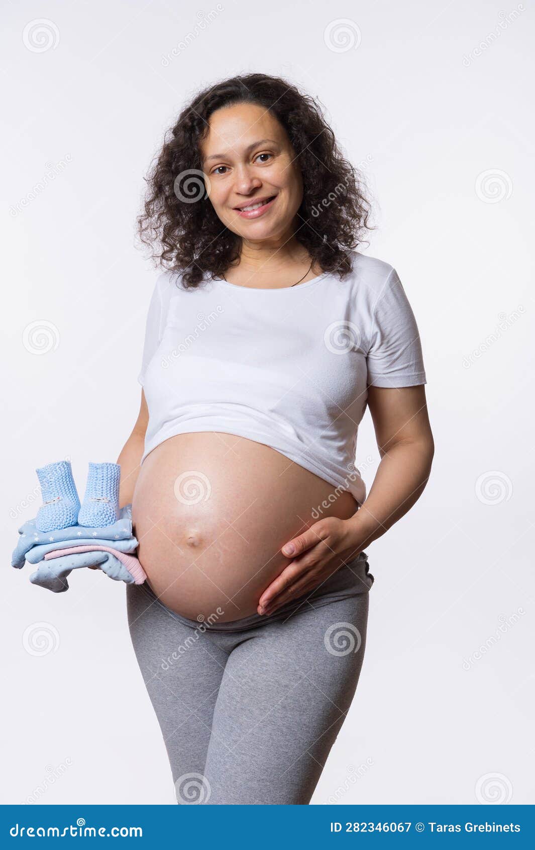 Mid-section of pregnant woman holding headphones at her belly stock photo