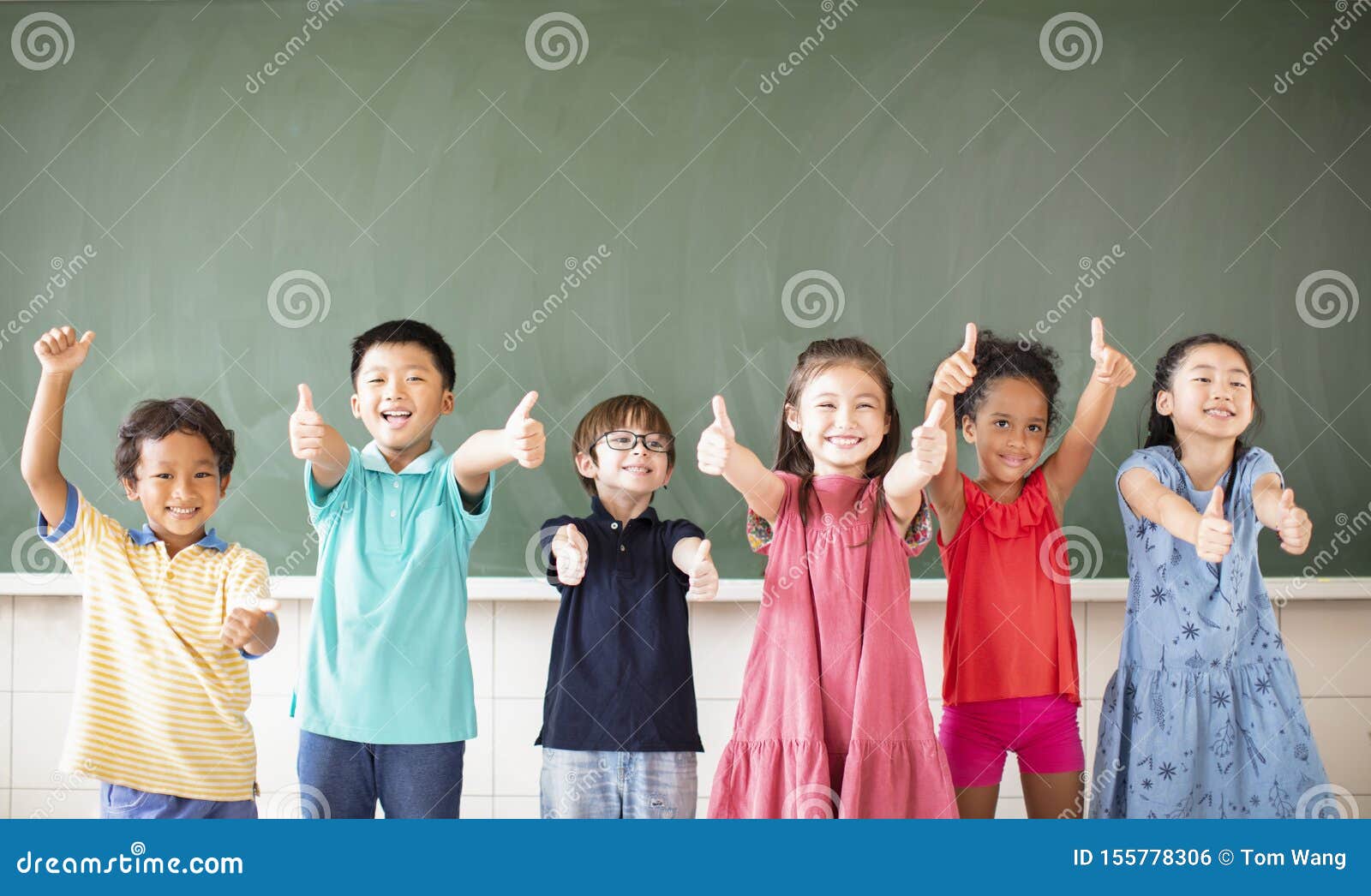 Multiethnic Group of School Children Standing in Classroom Stock Photo