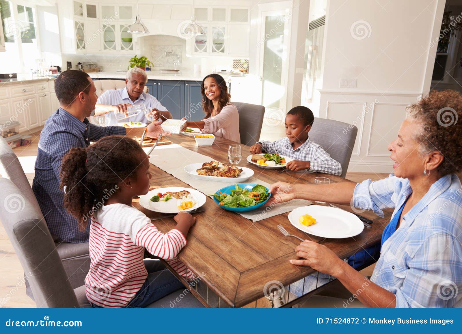 Multi Generation Black Family Serving a Meal in the Kitchen Stock Photo