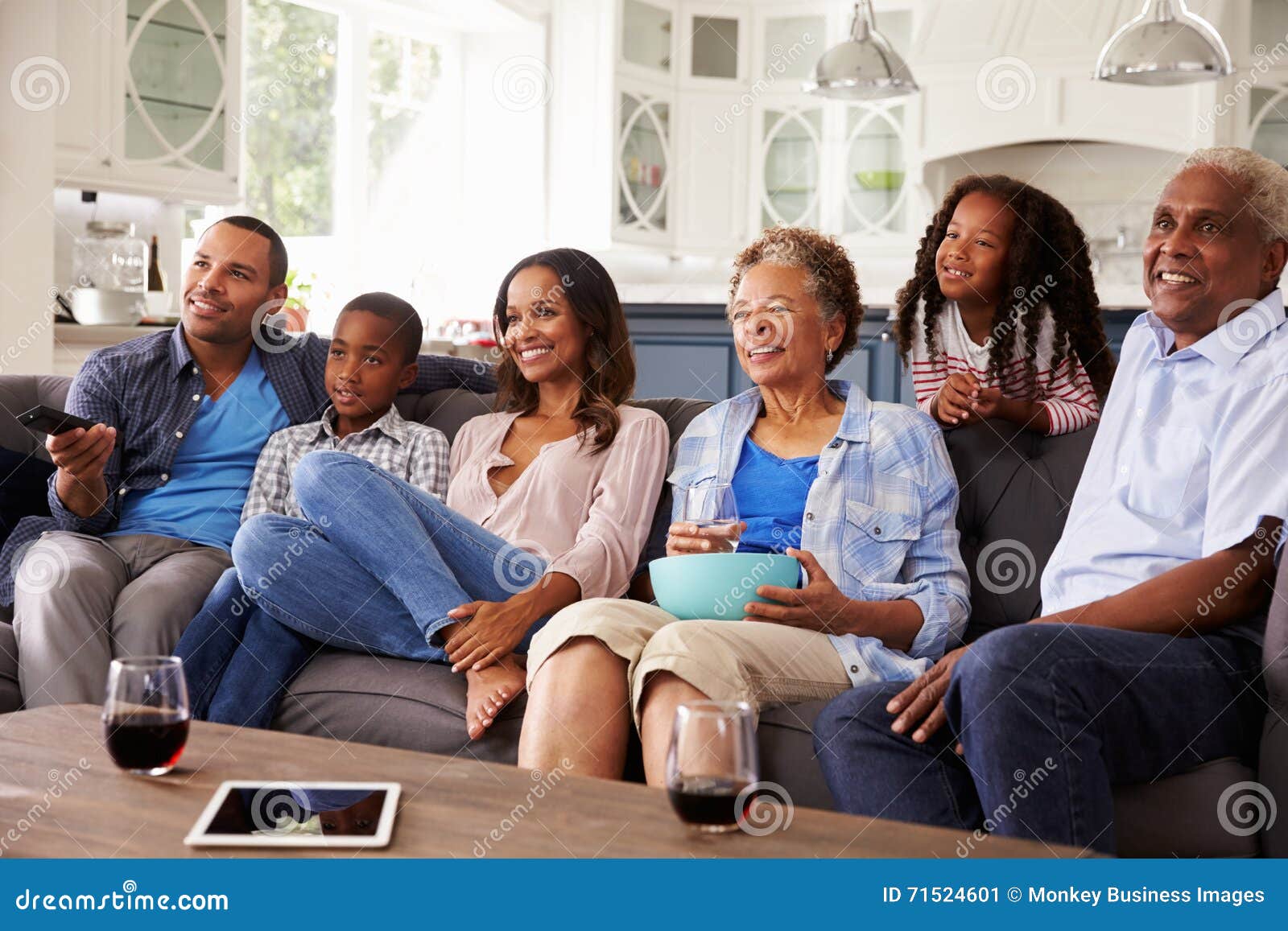 multi generation black family watching movie on tv together