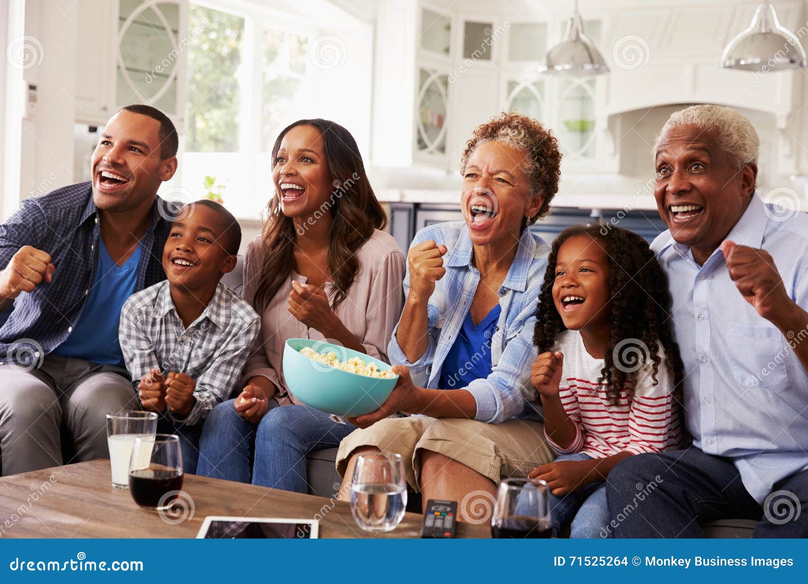 multi generation black family watching sport on tv at home