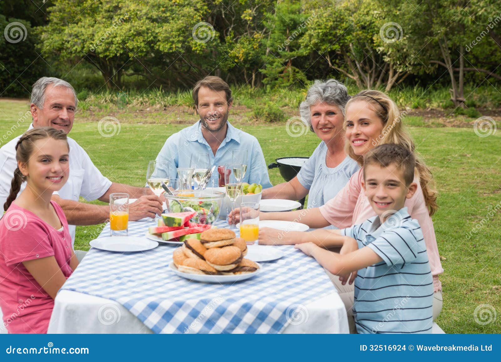 Multi Generation Family Having Dinner Outside At Picnic ...