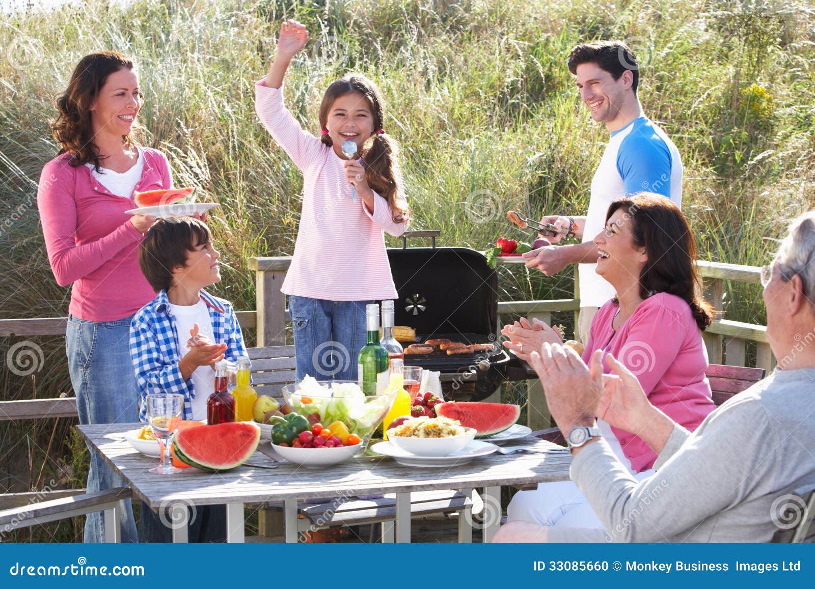 multi generation family having outdoor barbeque enjoying fun 33085660
