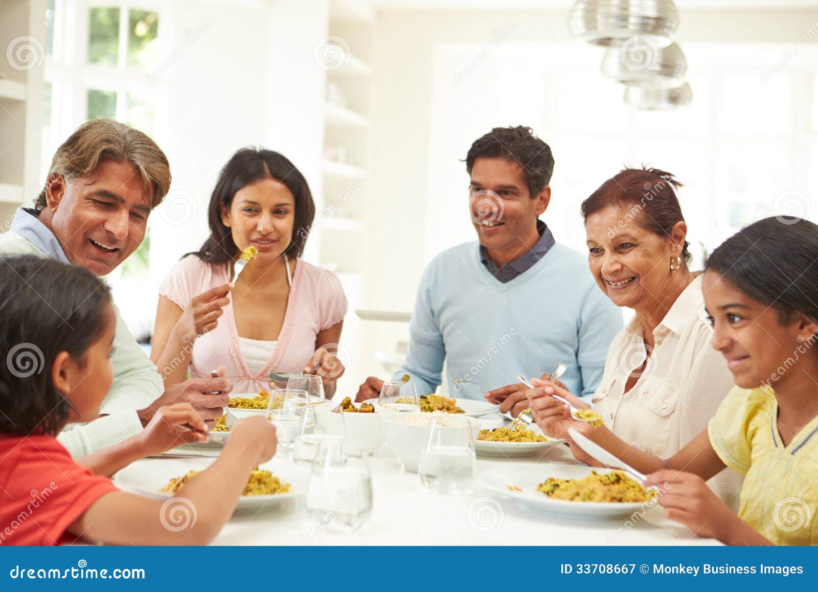 multi generation indian family eating meal at home