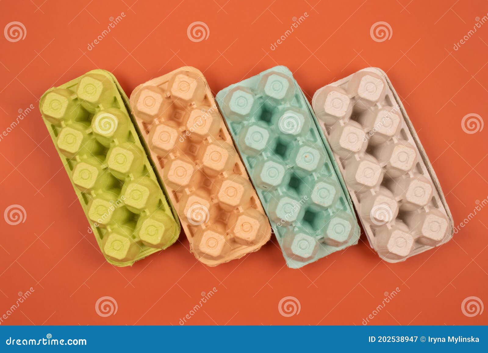 multicolored organic egg trays on orange background with copyspace for your text. biodegradable and compostable paper
