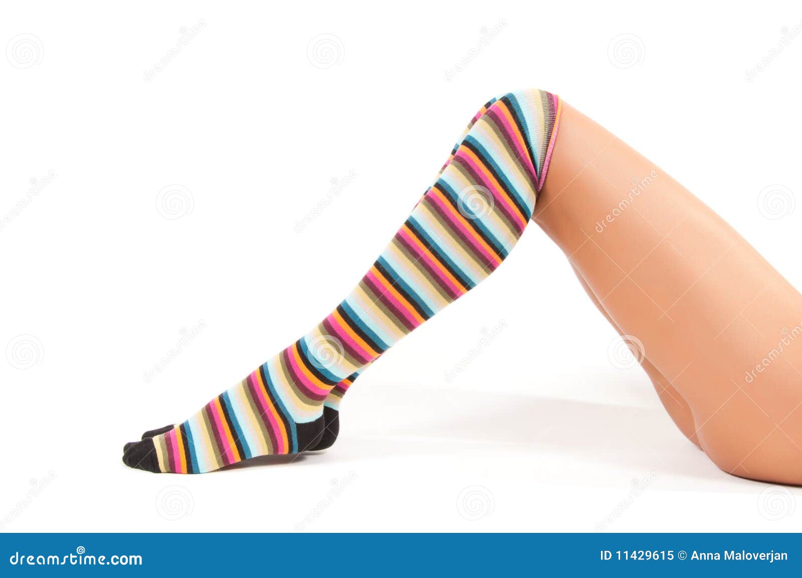 Shot of woman legs in multicolored stockings sitting onthe floor