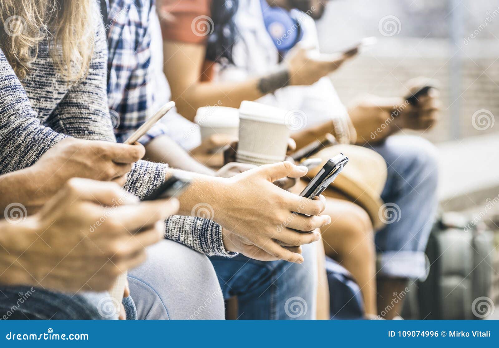 multicultural friends group using smartphone with coffee cup