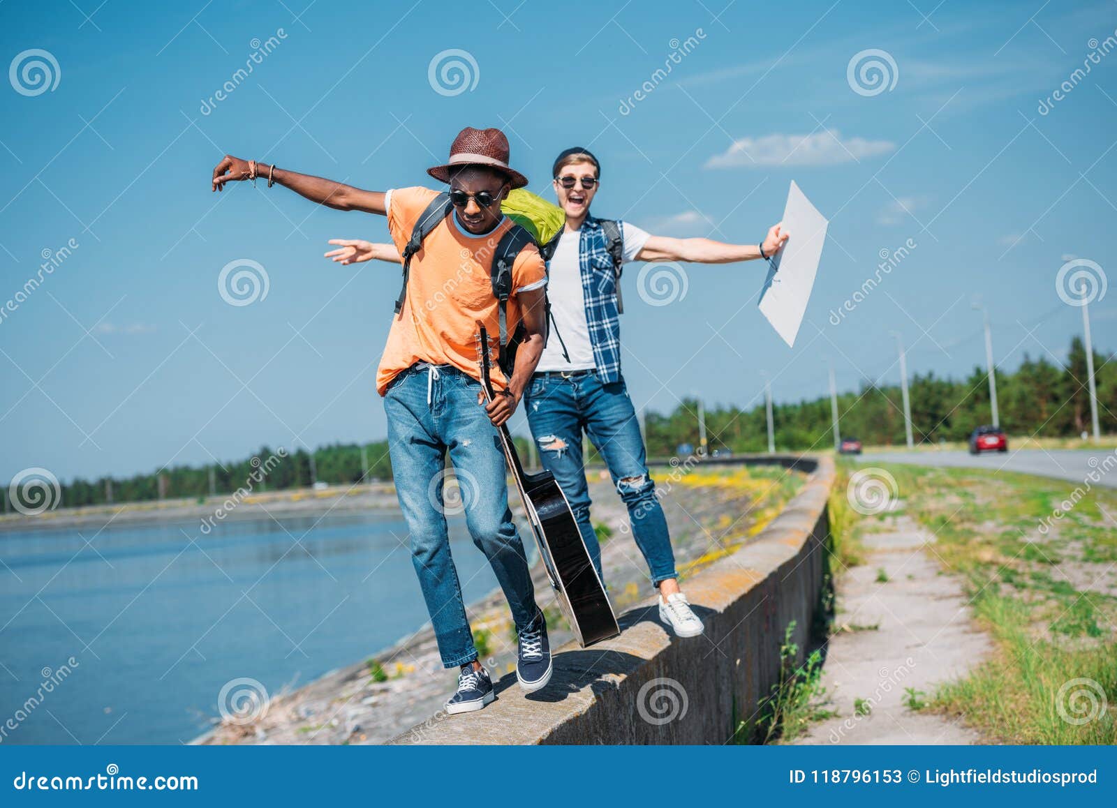 Multicultural Men with Empty Cardboard Walking on Parapet while Stock