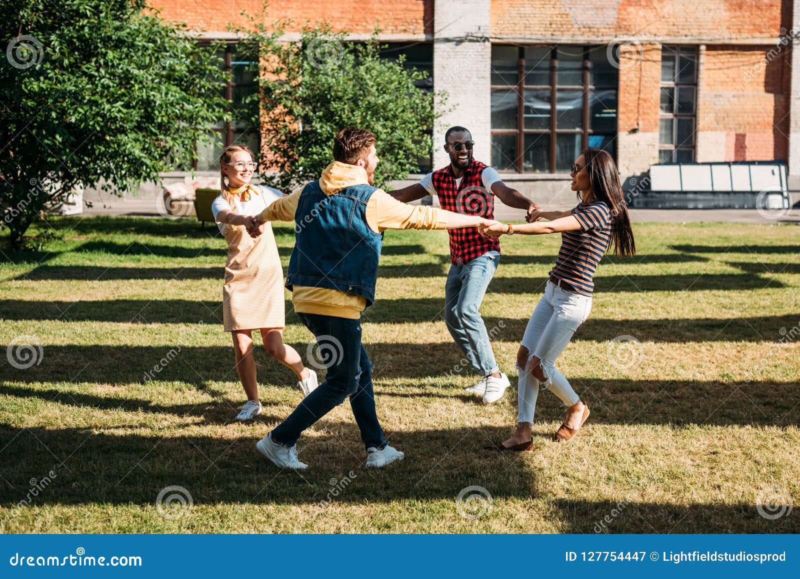 Multicultural Young Friends Holding Hands while Having Fun Together ...