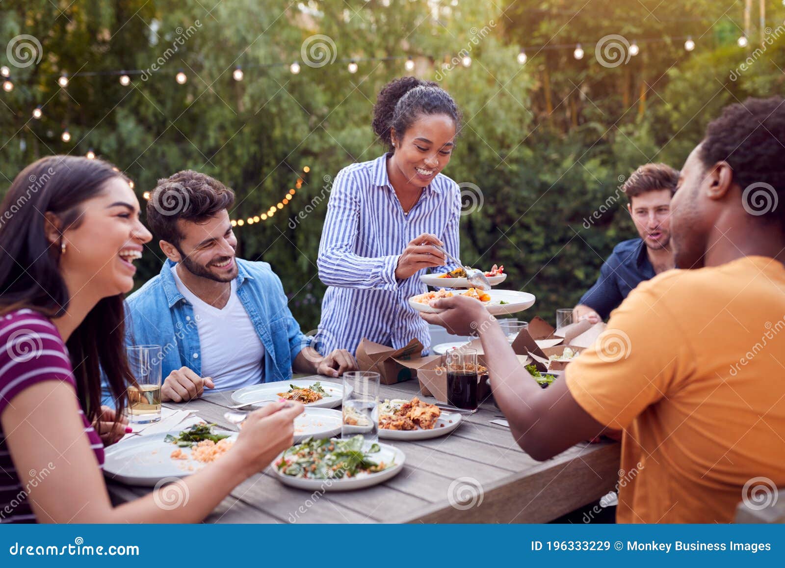 Vrienden Aan Tafel Die Genieten Van Eten Op Zomertuinfeest Afbeelding - Image of eten, kletsen: 196333229