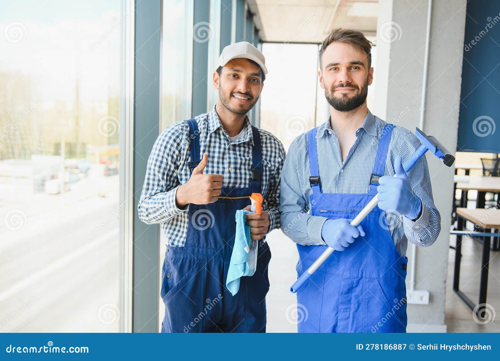 Multiethnic Professional Cleaners in Uniform Washing Large Windows in