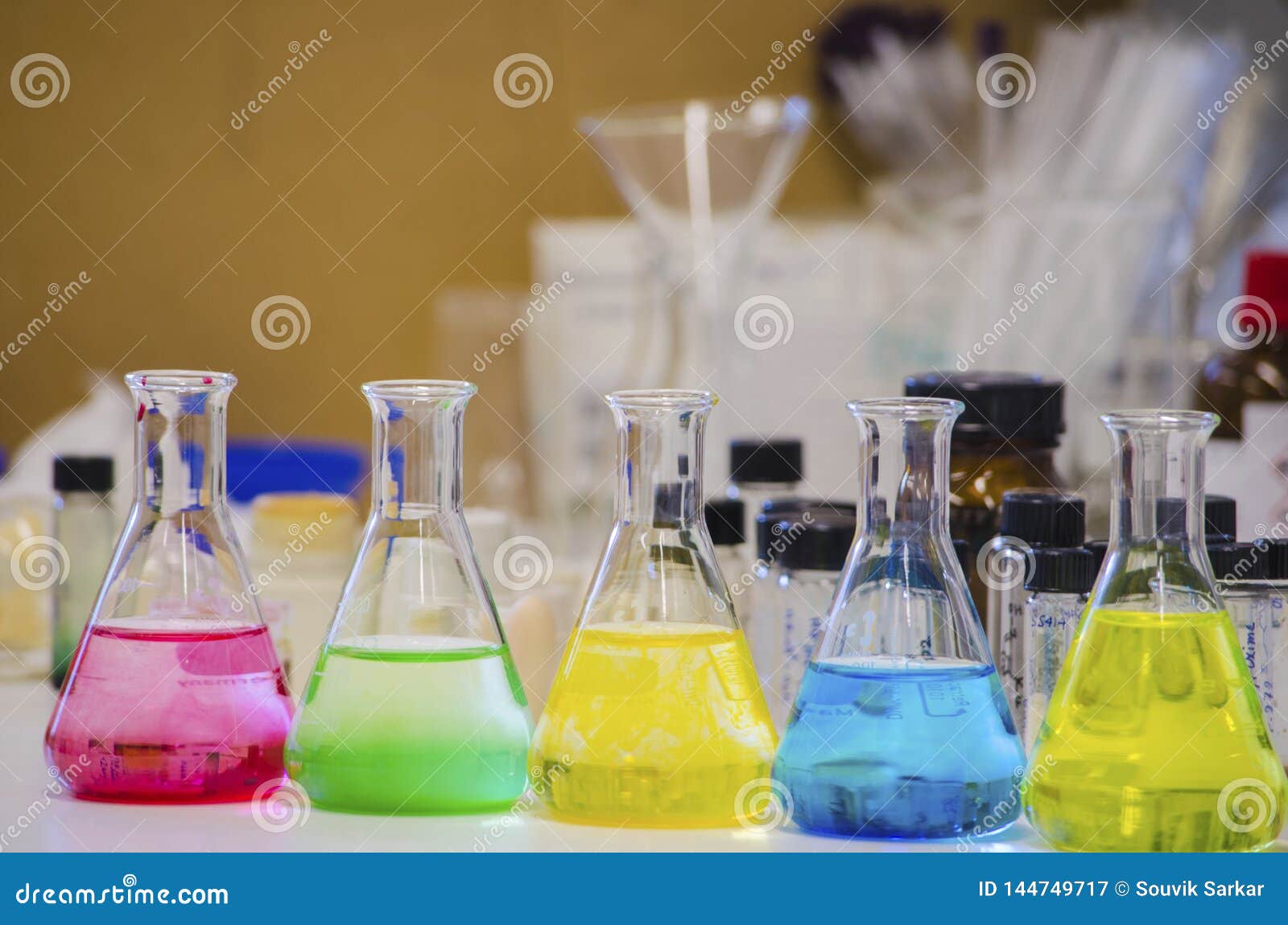 Multiple Colorful Solution In Conical Flask Lined On A Bench In A
