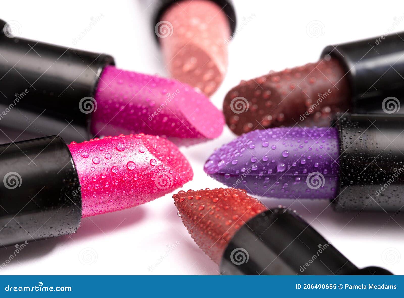 Multiple Tubes of Different Colored Lipsticks on a White Background
