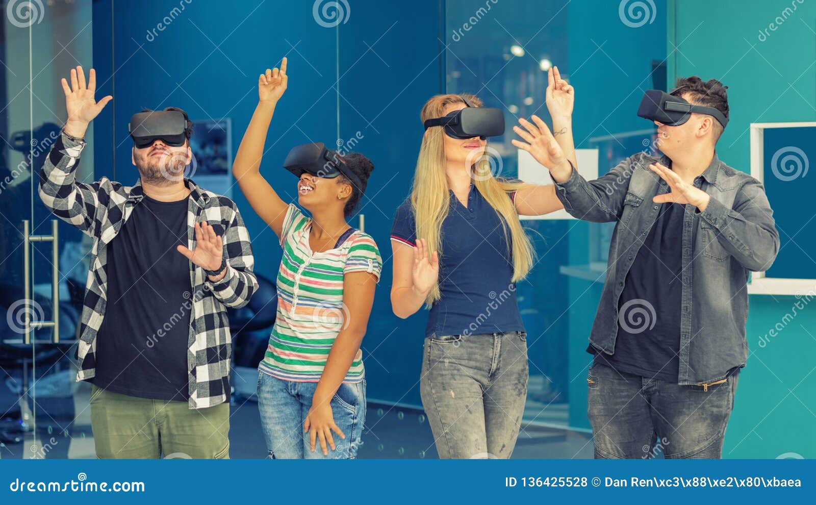 multiracial friends group playing on vr glasses indoors. virtual reality concept with young people having fun together.