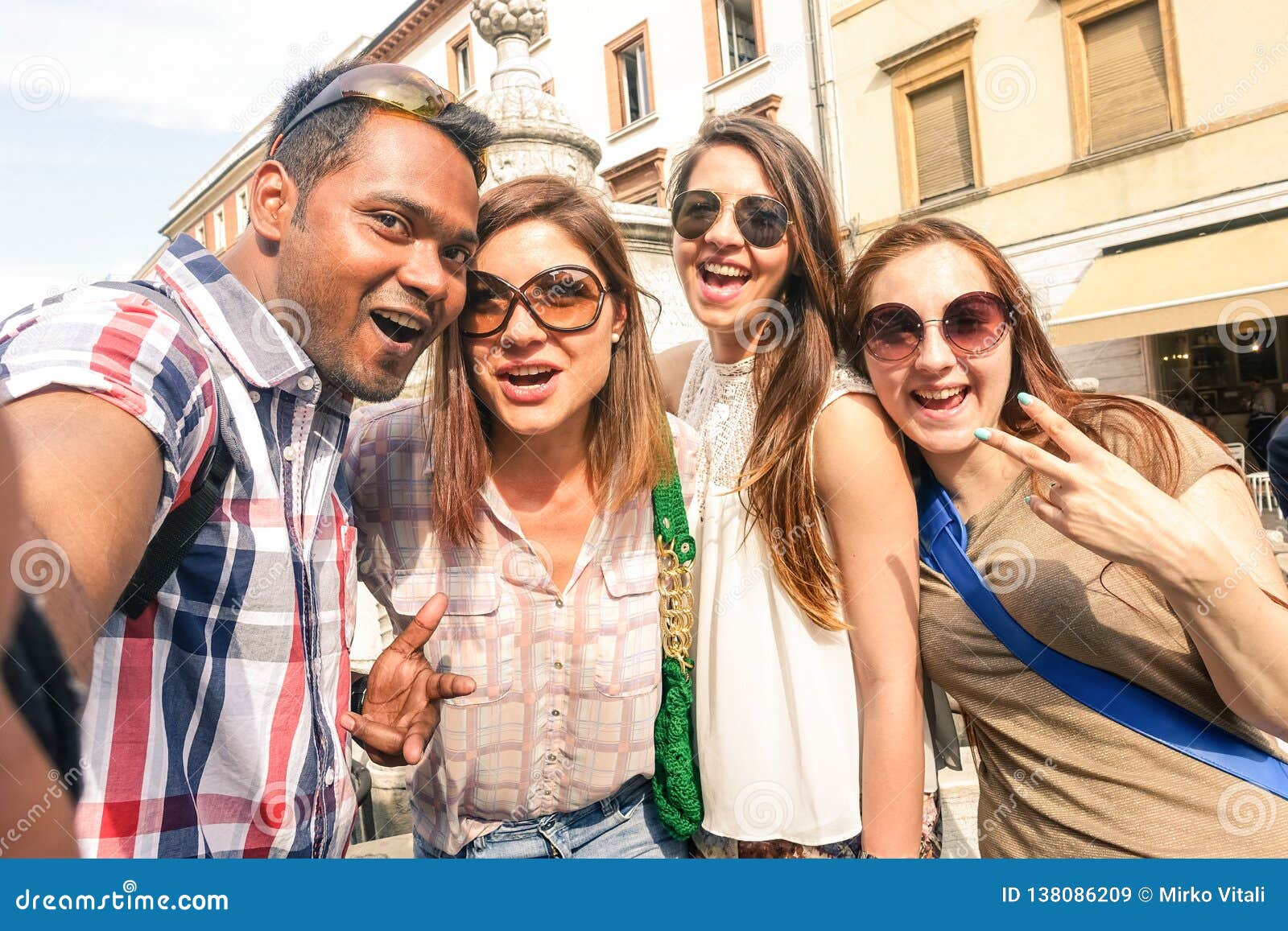 multiracial friends taking selfie at city tour - happy friendship concept with gen z student having fun together - millenial