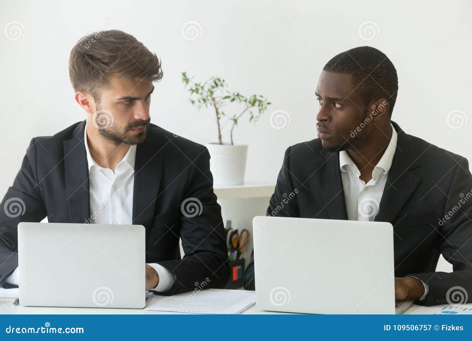 multiracial office rivals looking at each other, rivalry at work