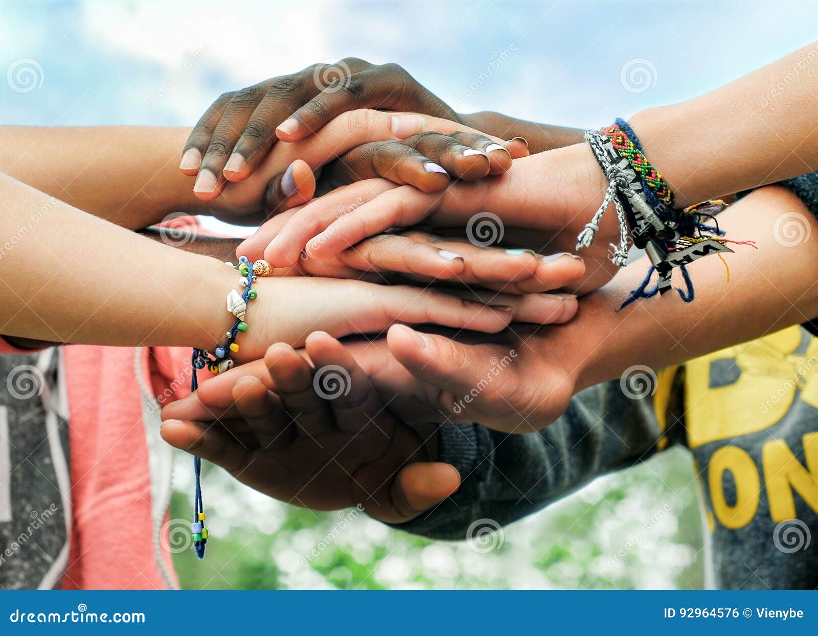 multiracial teen friends joining hands together in cooperation