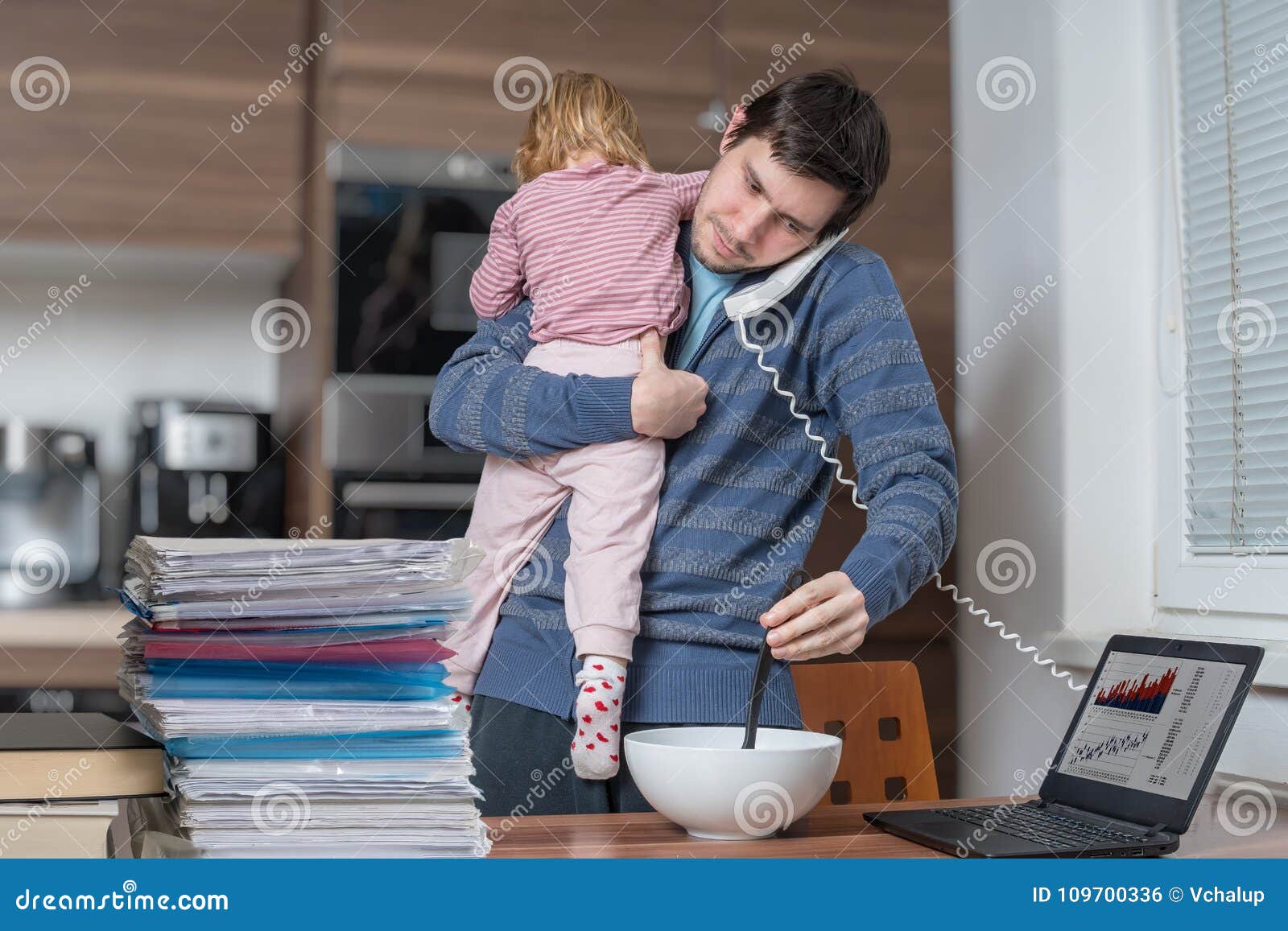 multitasking father is babysitting and working at home