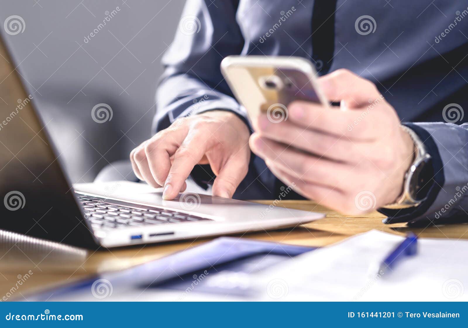 multitasking and mobile technology. busy workaholic business man using phone and laptop. entrepreneur working hard with smartphone