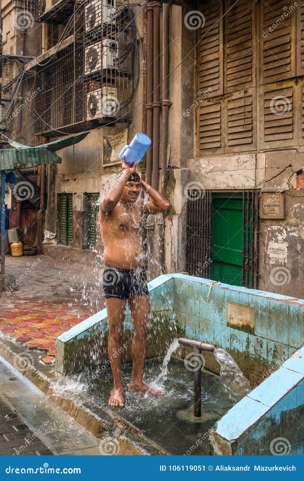 Indian Man Taking Shower From Bucket On Streets Of Mumbai India 