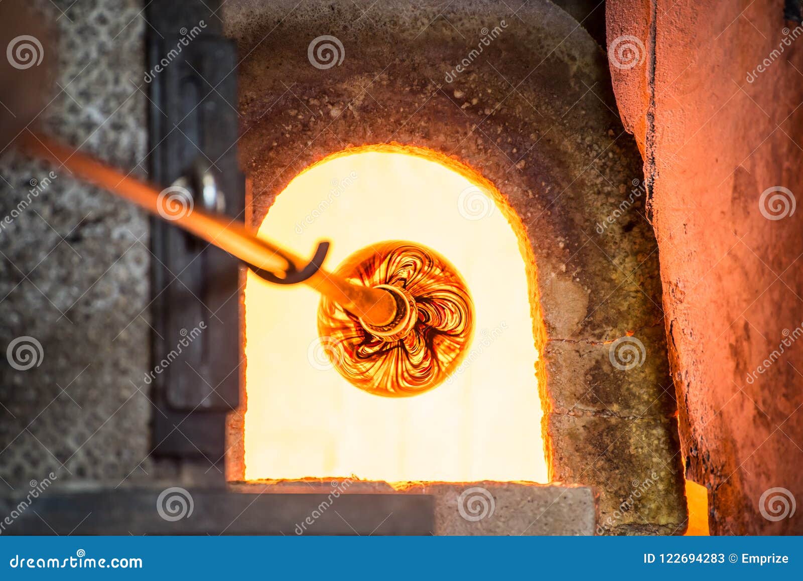 murano glass-blowing factory. glass blower forming beautiful pie