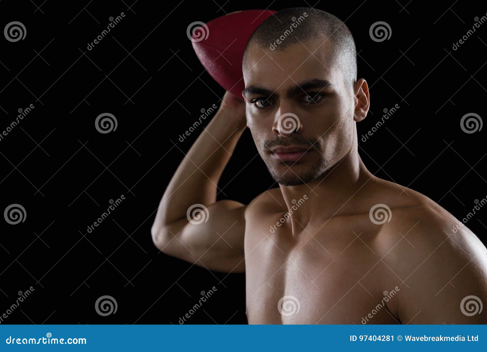 Muscular American Football Player Holding a Football in His Hand Stock